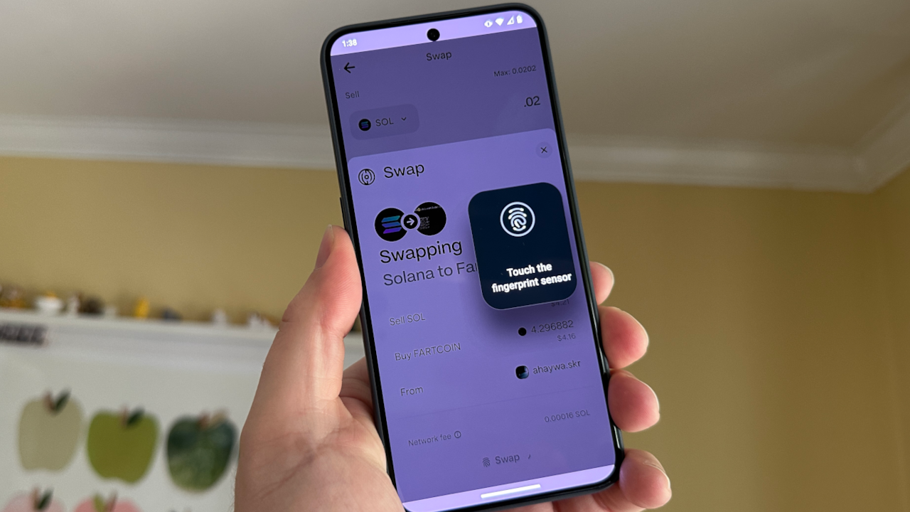 User approving a token swap on Jupiter using fingerprint authentication on a Solana Saga phone